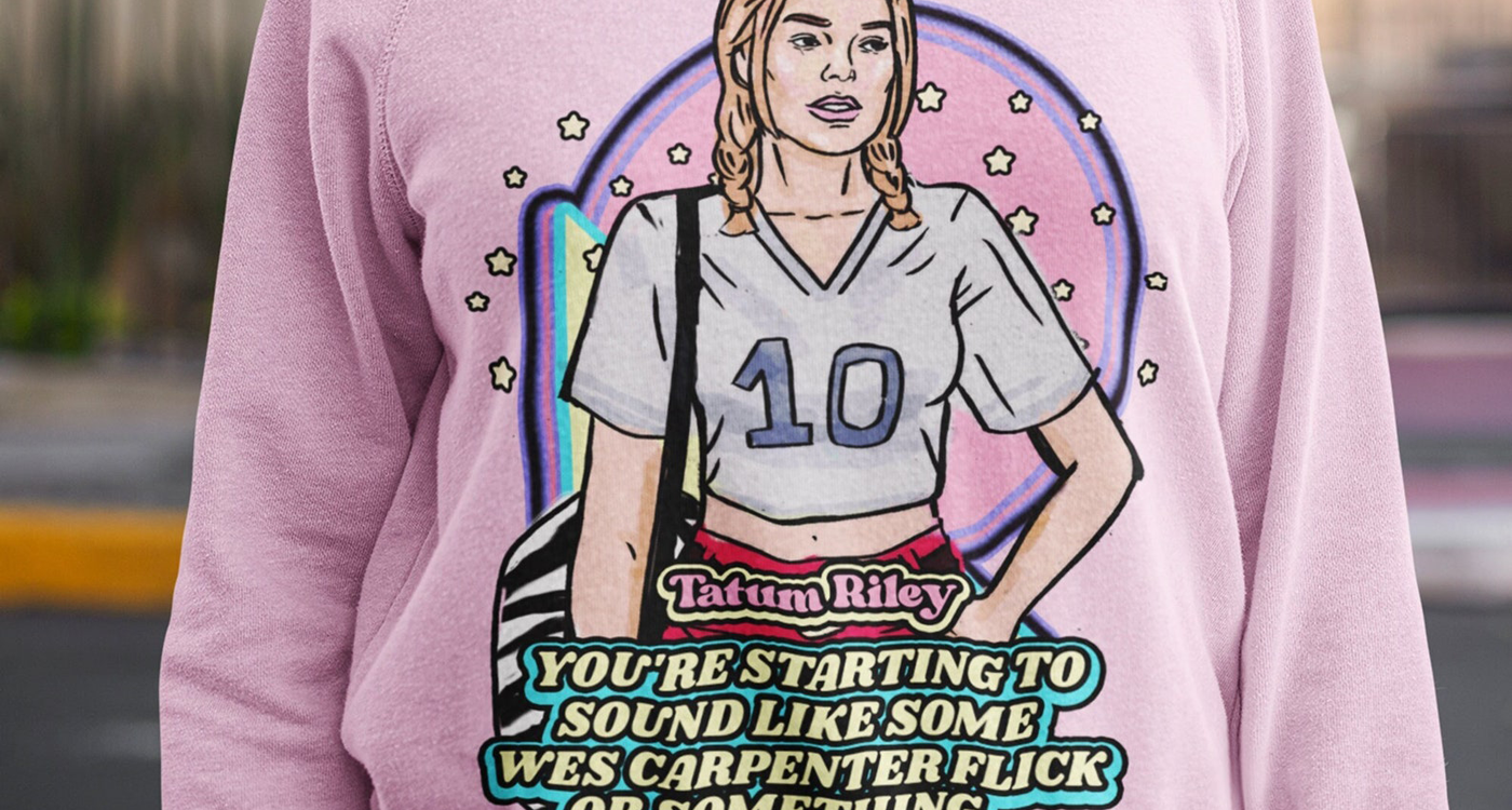 Closeup photo of female model wearing pastel pink crew neck sweatshirt with retro illustration of Tatum Riley (Rose McGowan) from Scream (1996) with movie quote below